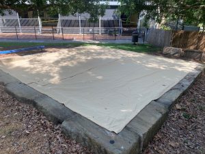 Why should a sand pit cover fully enclose the sand pit?