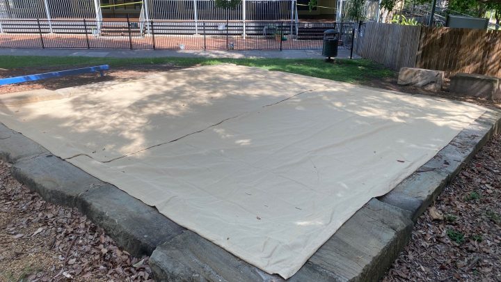 Why should a sand pit cover fully enclose the sand pit?